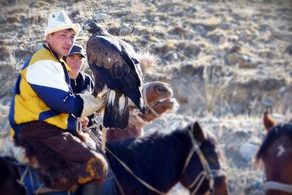 young kyrgyz men on horse with eagle young kyrgyz men on horse with eagle