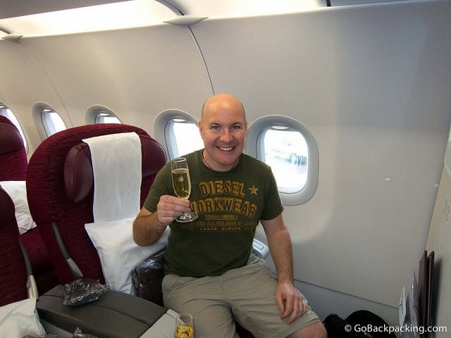 Drinking a glass of pre-flight champagne in business class on Qatar Airways