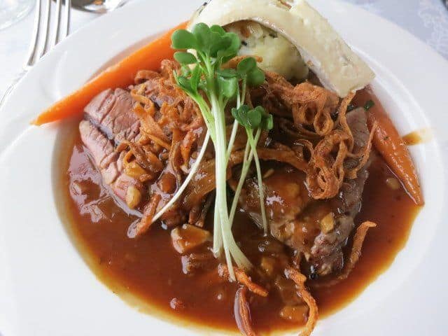 Roasted beef tenderloin The main course. Roasted beef tenderloin on a black truffle potato cake with onion ribbons and Cambozola cheese.