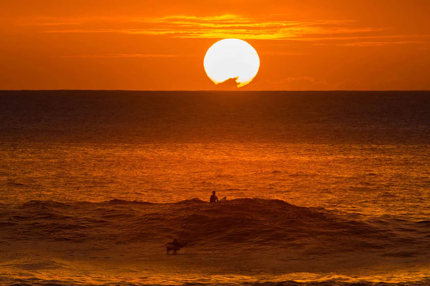 Sunset surfing in Oahu Hawaiian adventures (Credit: Anthony Quintano)