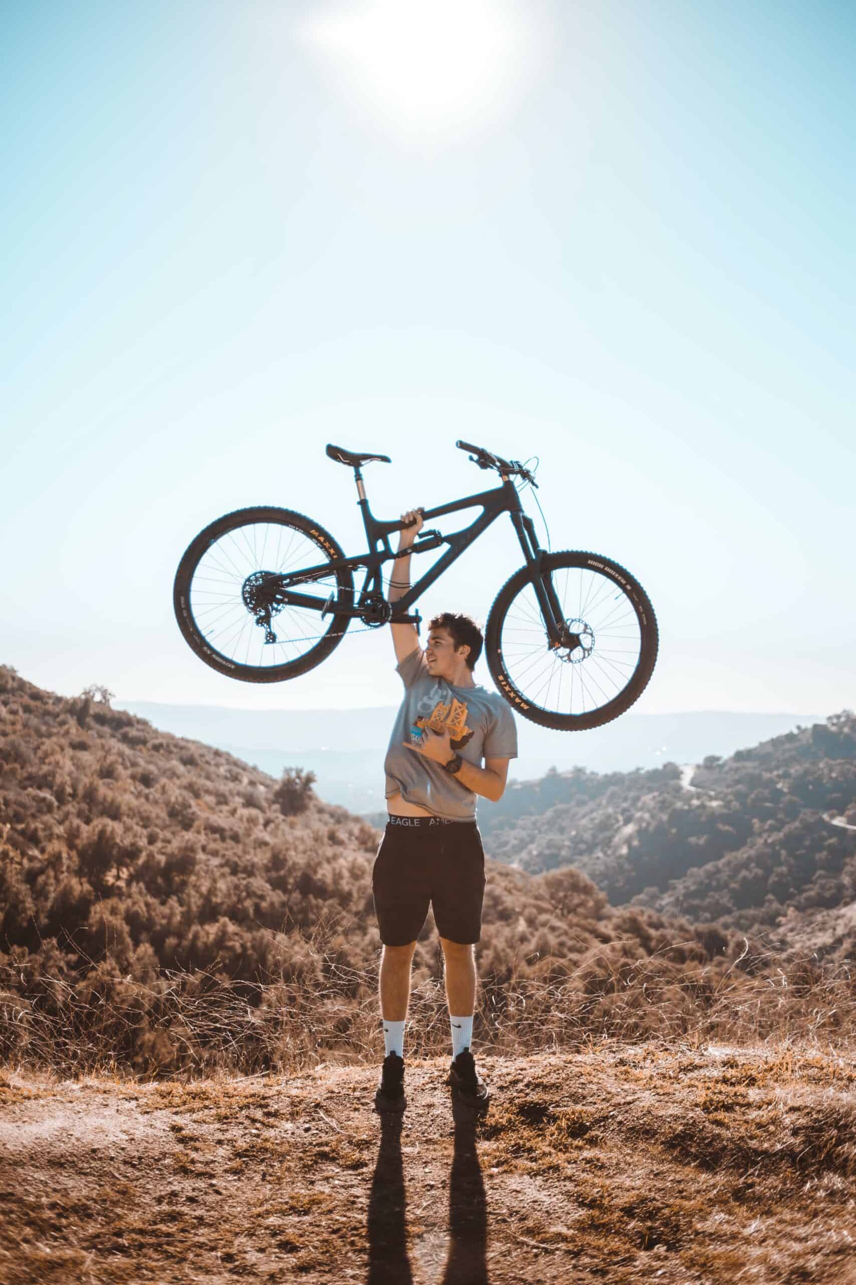 Man holding a full suspension bike (photo: Clayton Cardinalli)