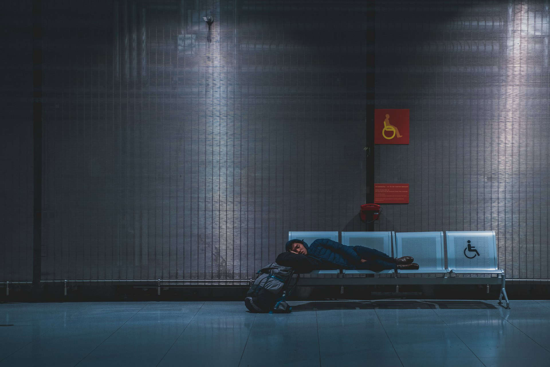Catching up on sleep is a good way to make the most of travel delays. Here, a backpacker sleeps at an airport in Germany (photo: Ilnur Kalimullin).