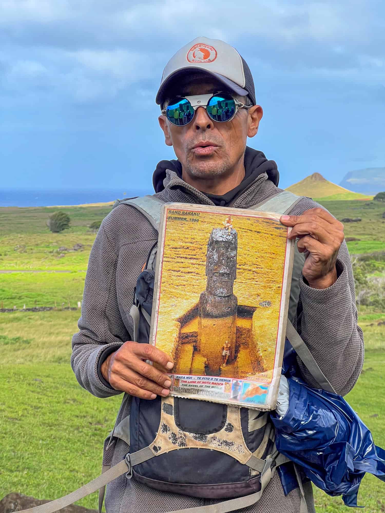 Our local guide shows a photo depicting the buried body of a moai statue.