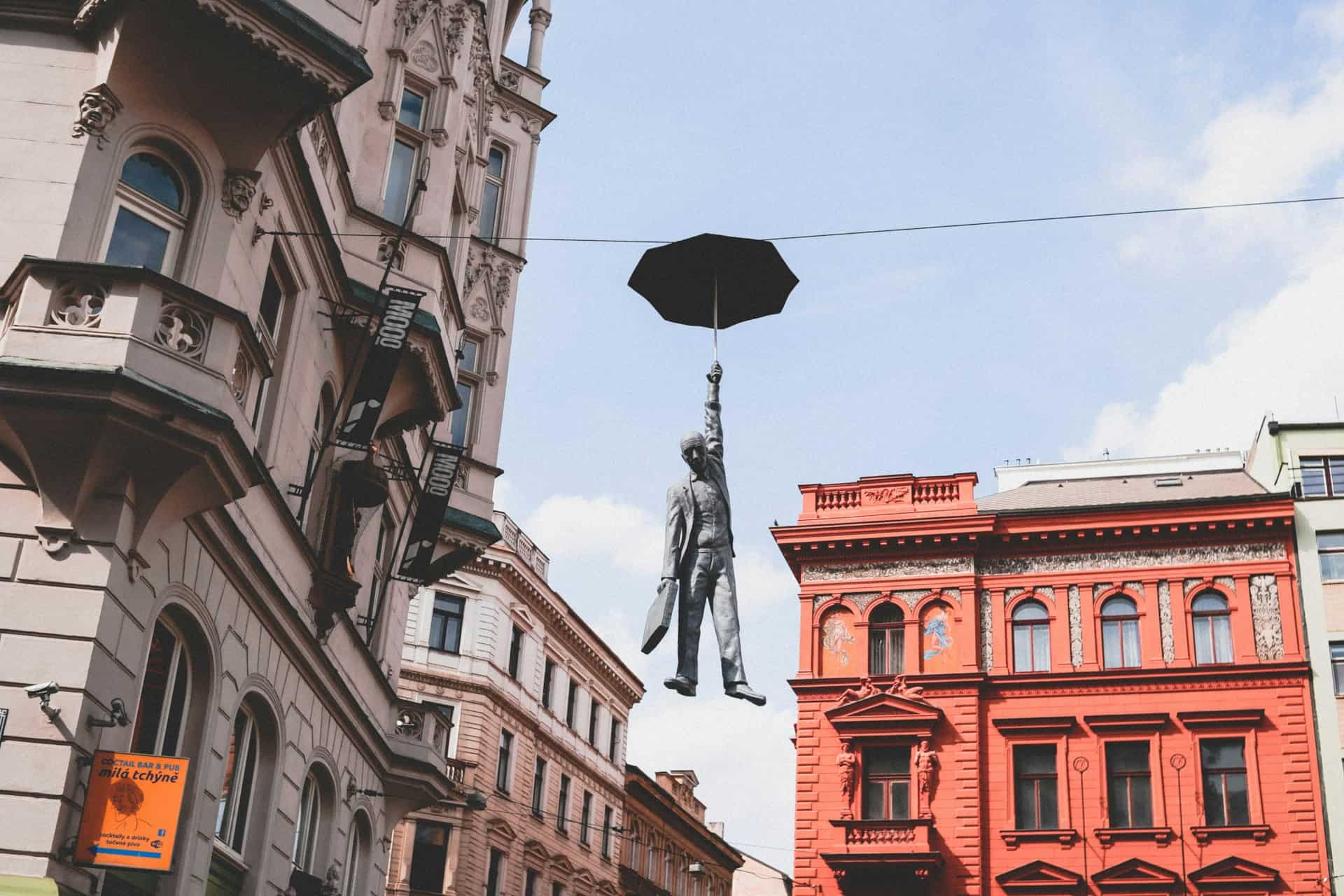Sculpture of a man hanging by an umbrella in Prague (photo: Nastya Dulhiier).