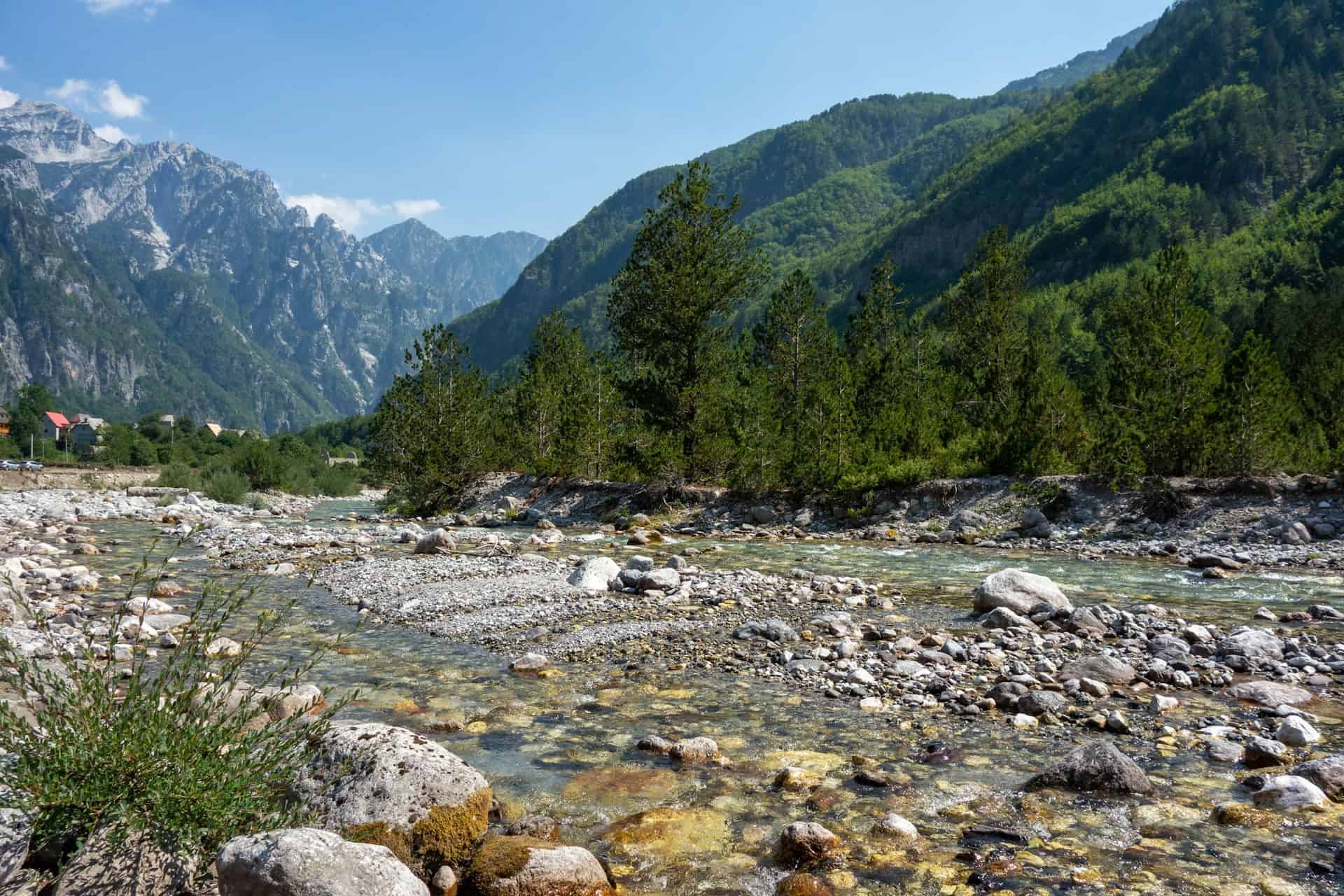 A river runs through the mountains of Theh, one of Albania's many scenic destinations (photo: Ilse, Unsplash).