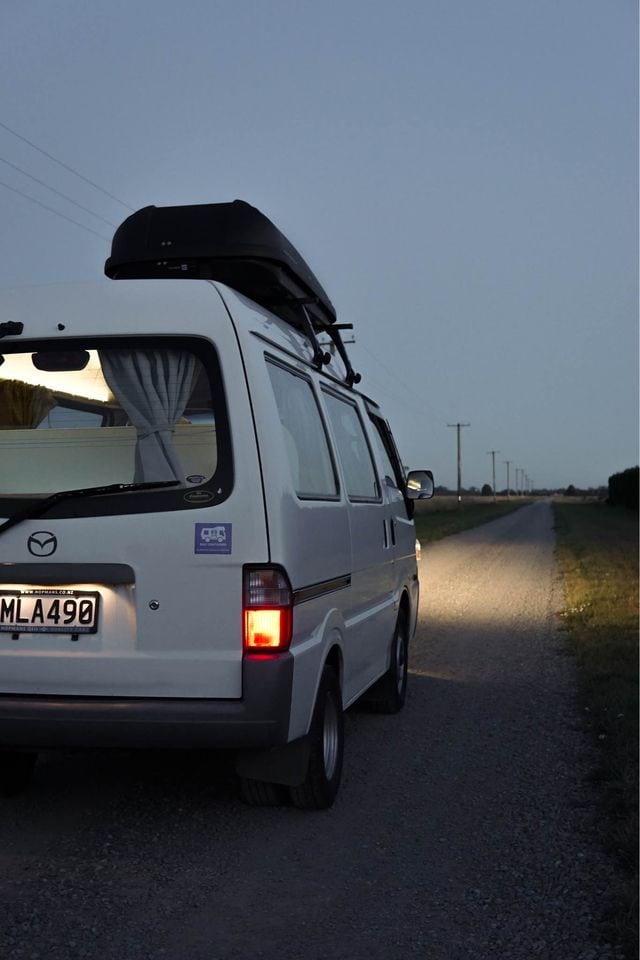 A campervan driving at night in New Zealand.