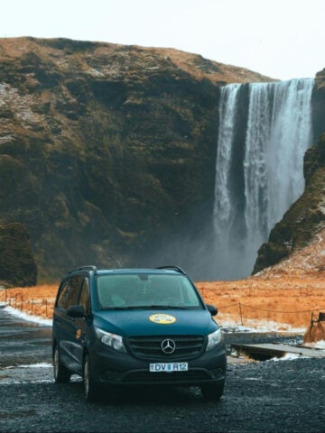 Mercedes campervan in front of a waterfall in Iceland.