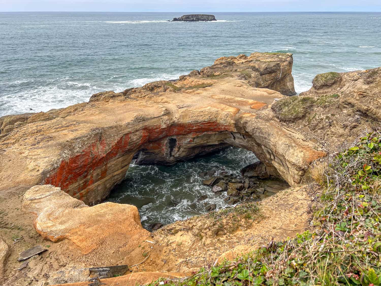 The Devils Punchbowl Arch at high tide.