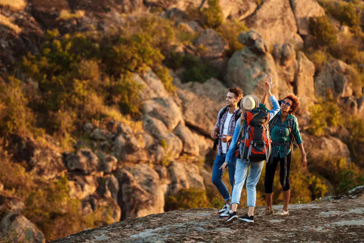 Hikers high-five in a canyon (photo by cookie_studio on Freepik).
