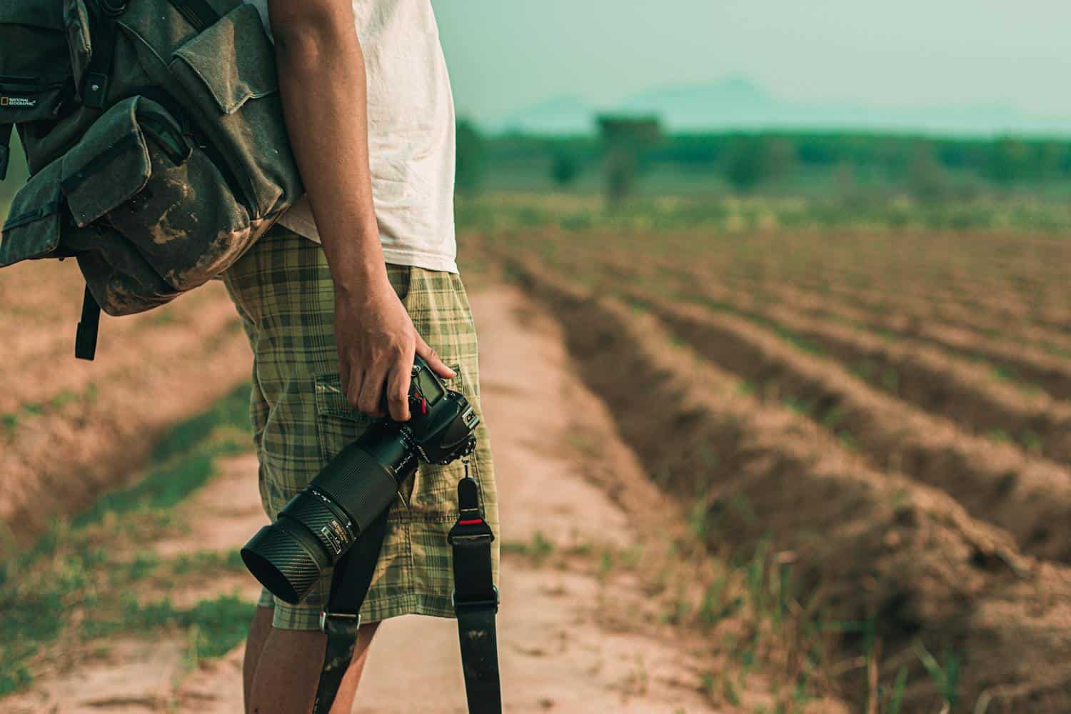 Man holding DSLR camera (photo: Mong Mong, Pexels).
