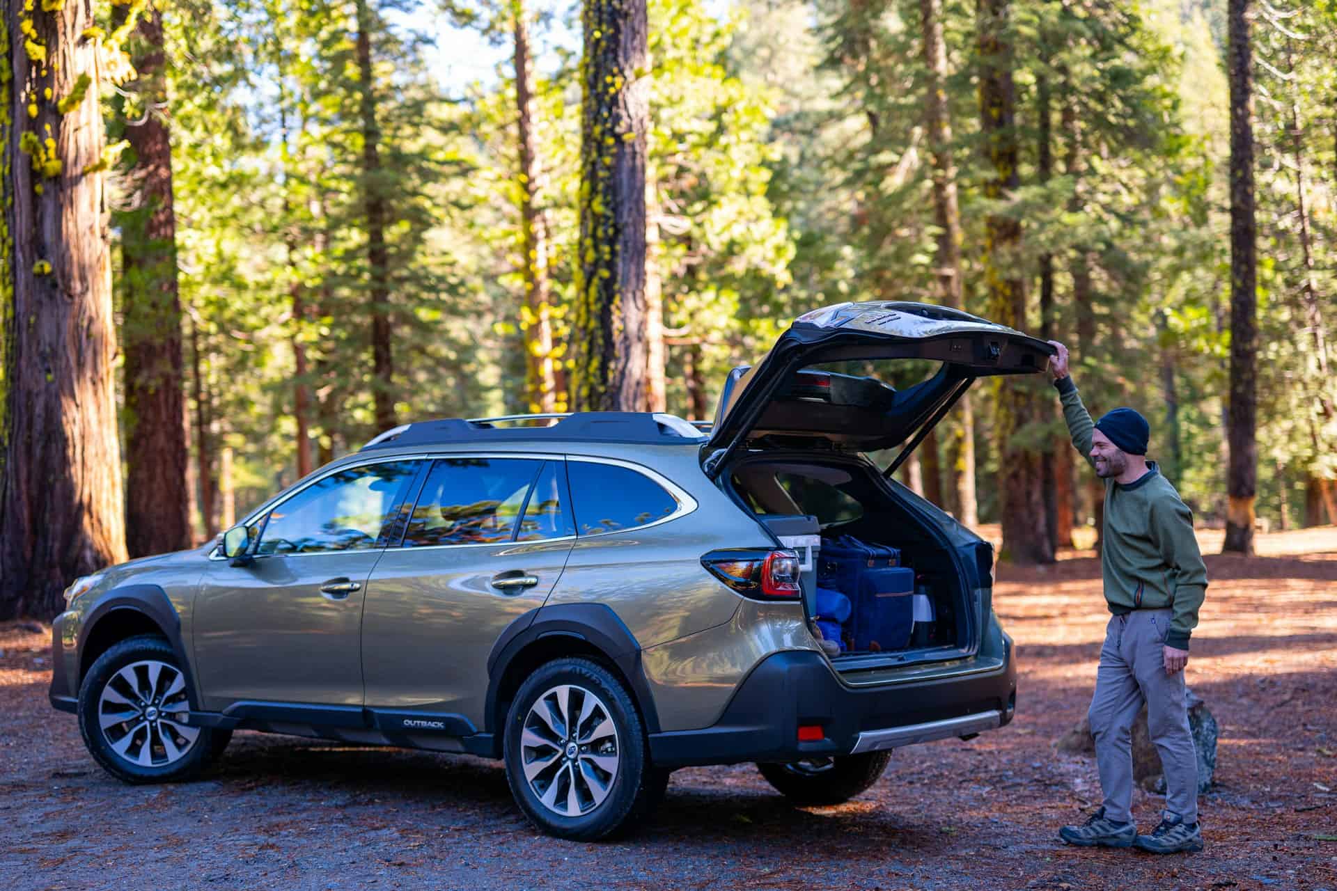 SUV with open cargo area at a forest campground during a family road trip