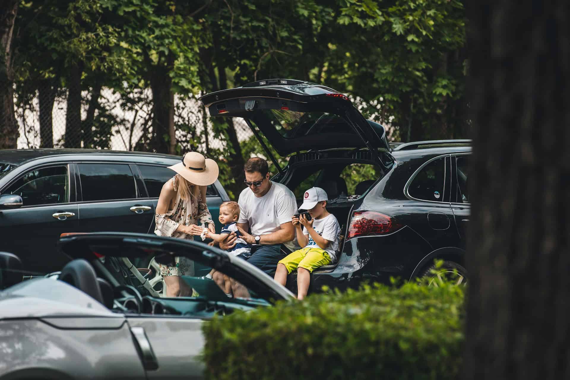 Family unloading an SUV during a road trip stop