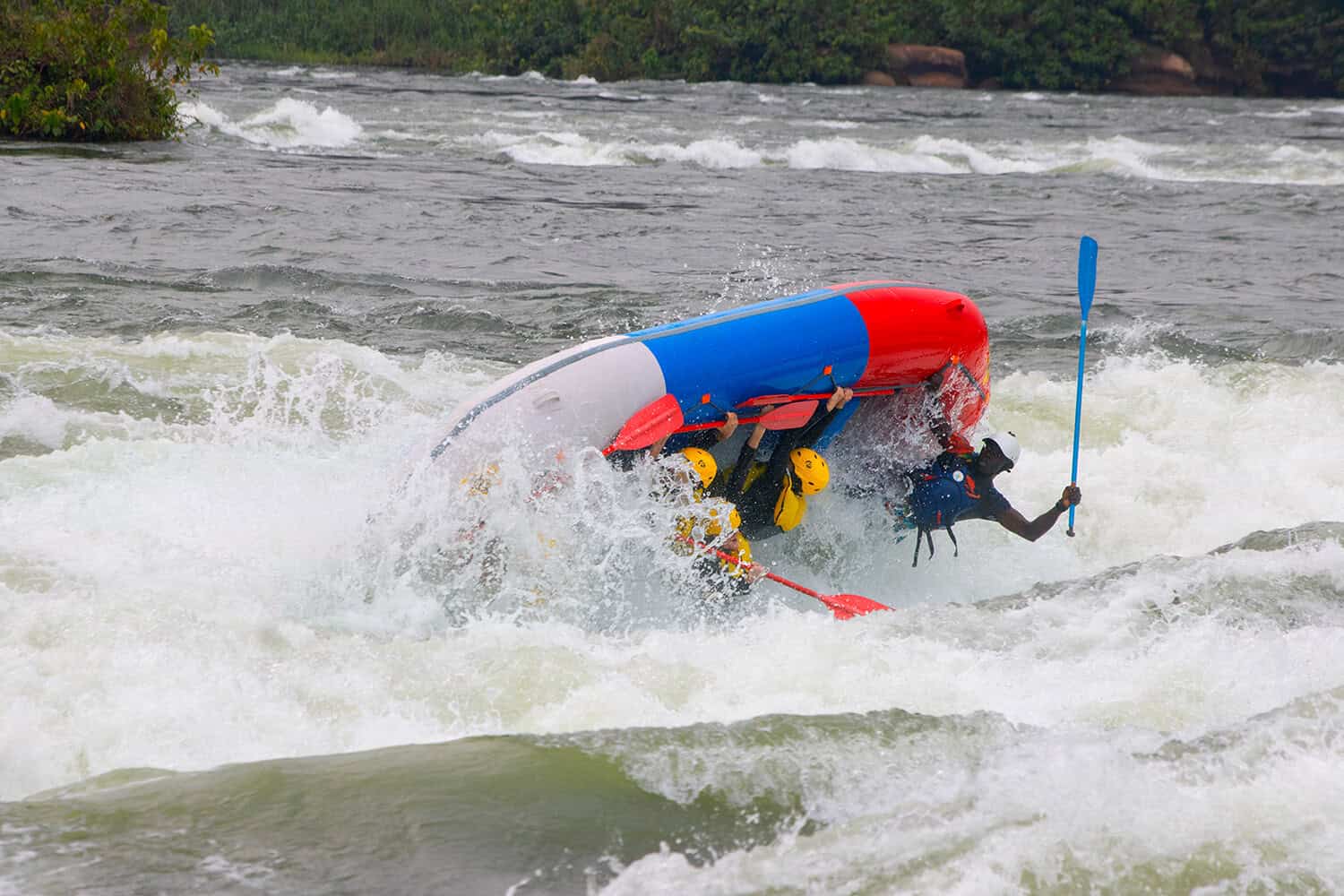 Raft flipping in powerful whitewater rapids on the Nile River in Uganda