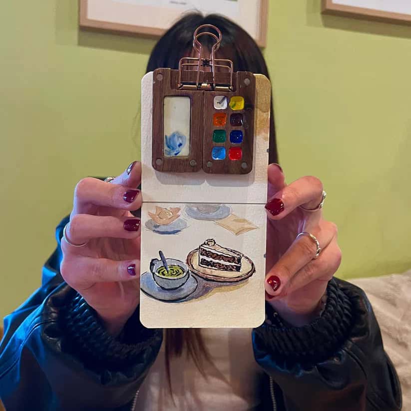 Pocket-sized watercolor kit and travel sketchbook used for painting on the go