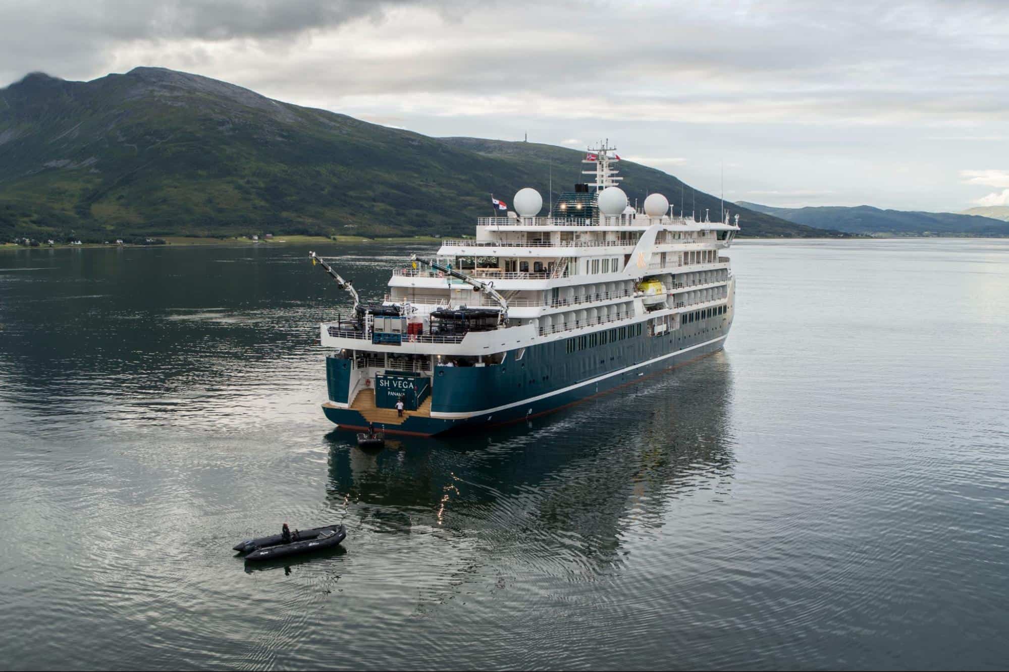 Swan Hellenic SH Vega expedition cruise ship sailing in Arctic waters near mountainous coastline