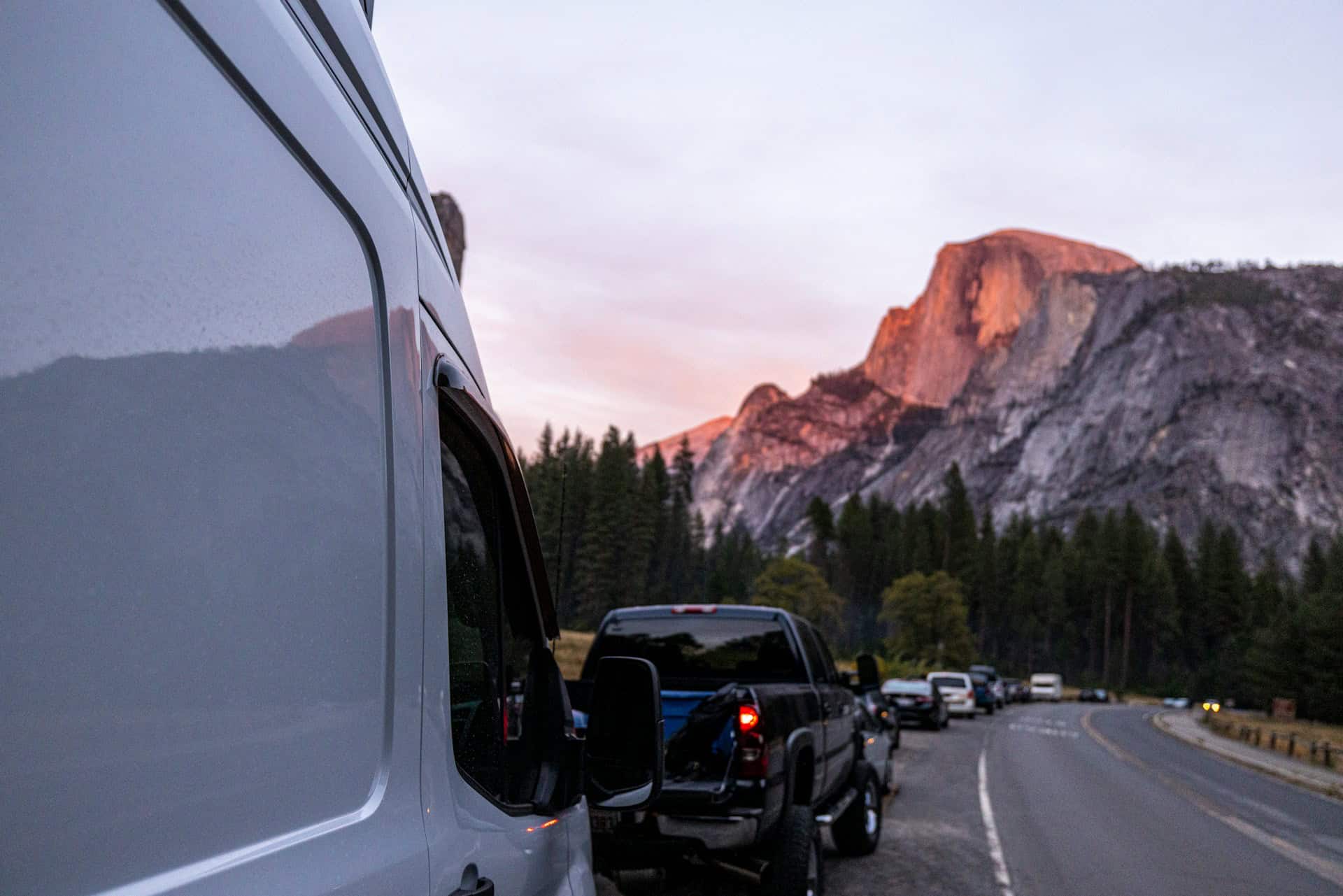 Vehicles parked near Yosemite National Park at dusk during a road trip