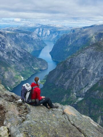 Hiker overlooking a fjord from the Bakkanosi viewpoint near Gudvangen, Norway.