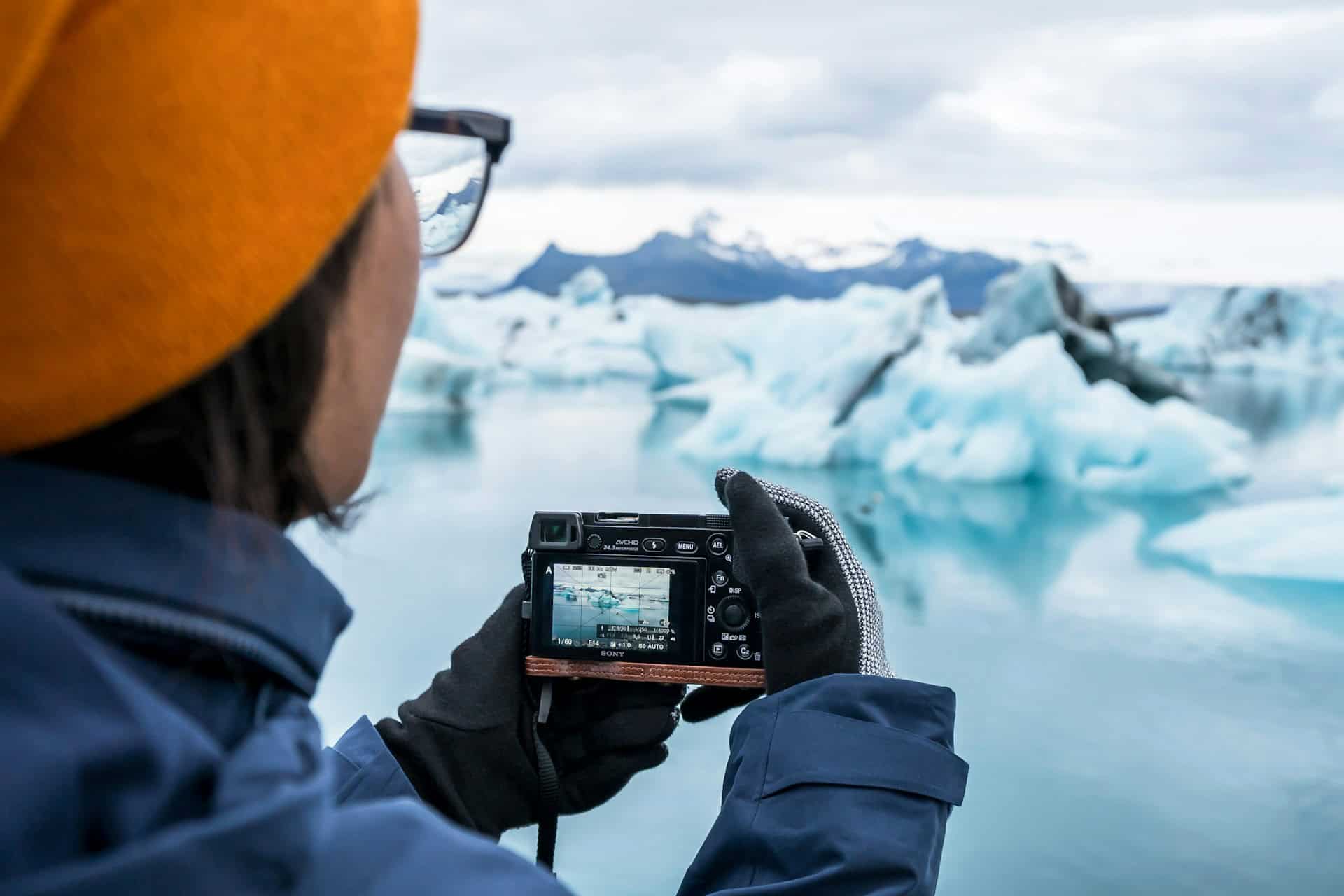 Traveler photographing icebergs in the Arctic with a mirrorless camera