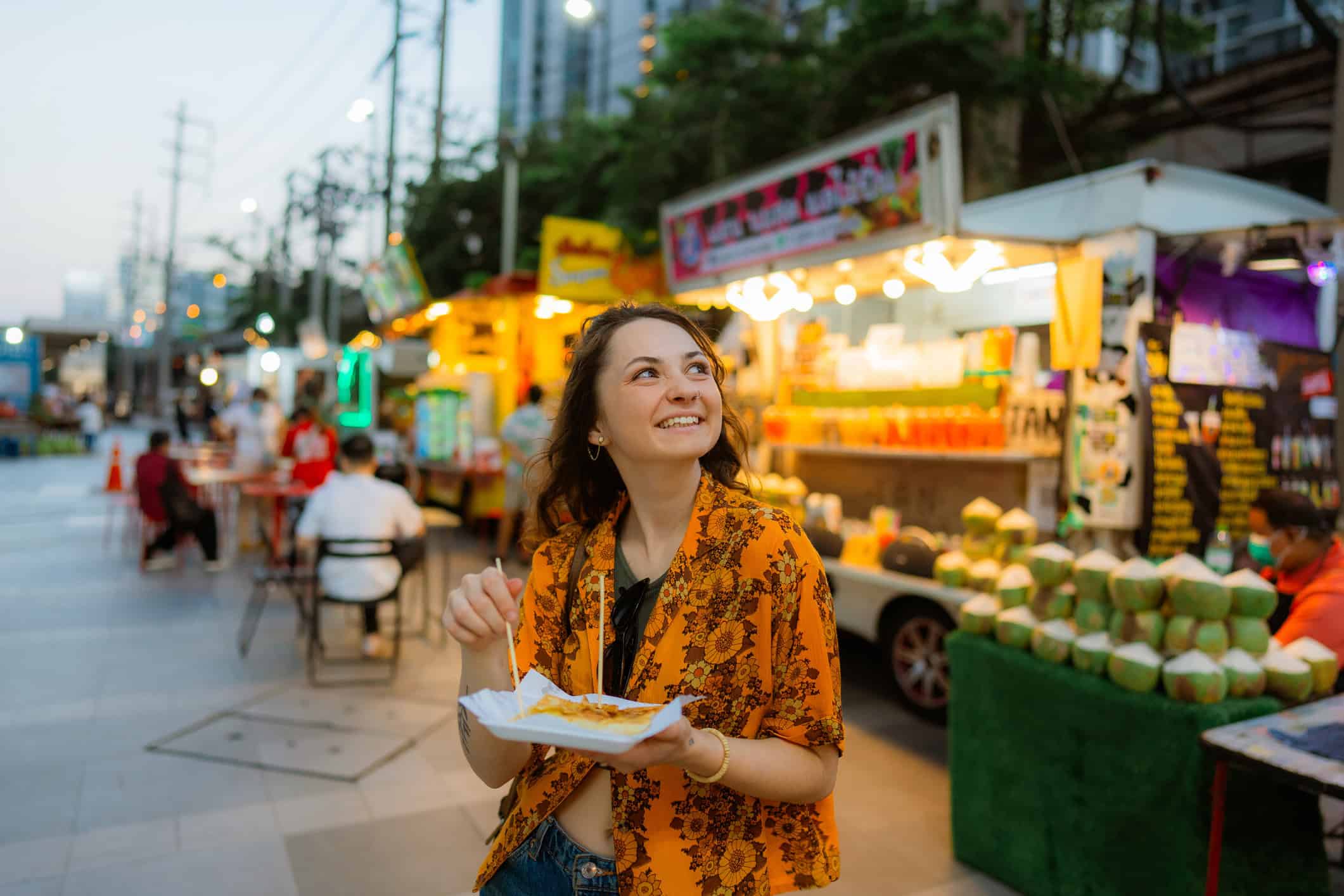Traveler enjoying street food at a night market in Bangkok, Thailand.