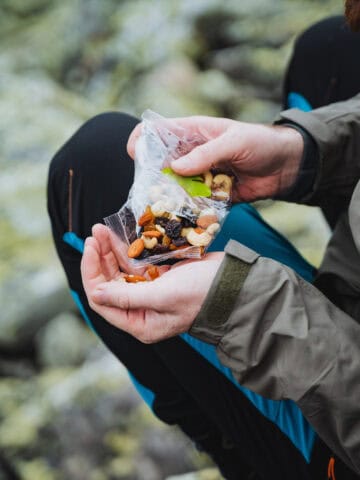 Backpacker eating lightweight trail snacks during a mountain hike