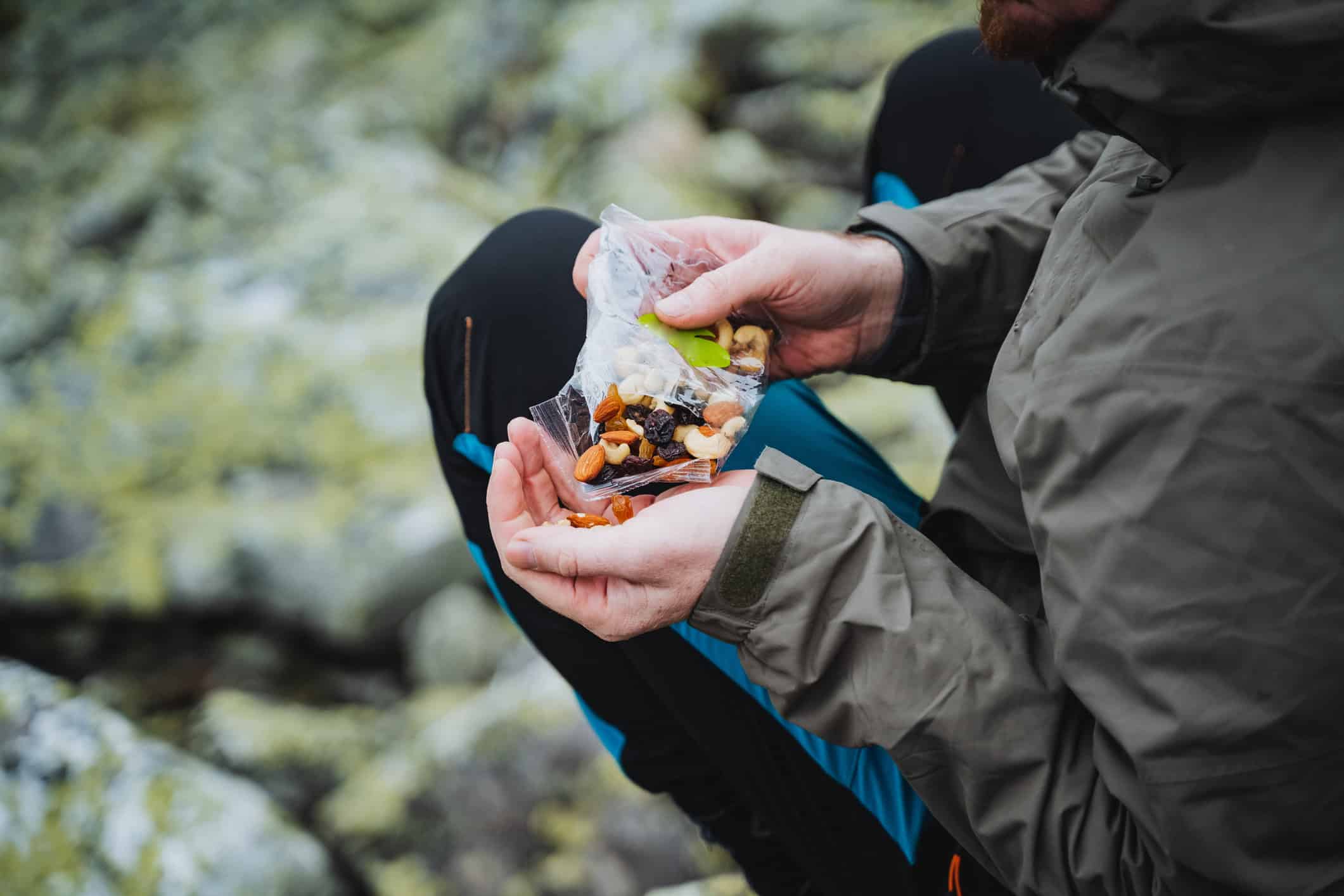 Backpacker eating lightweight trail snacks during a mountain hike