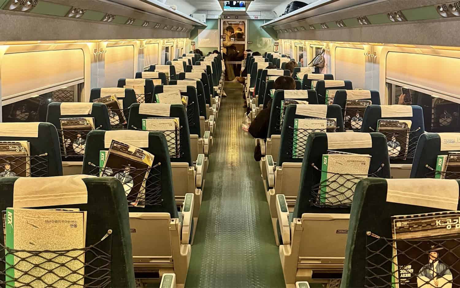 Inside a KTX-I cabin, looking down the aisle between rows of seats