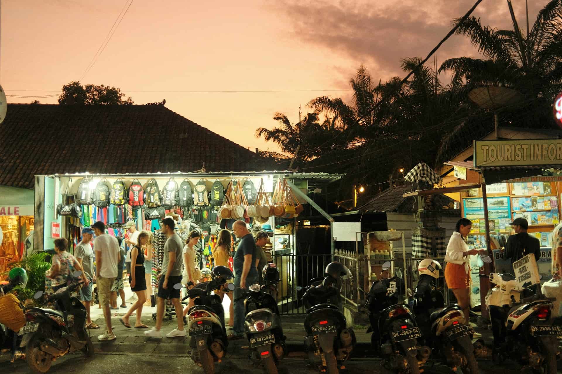 Travelers and scooters at a market street in Seminyak, Bali