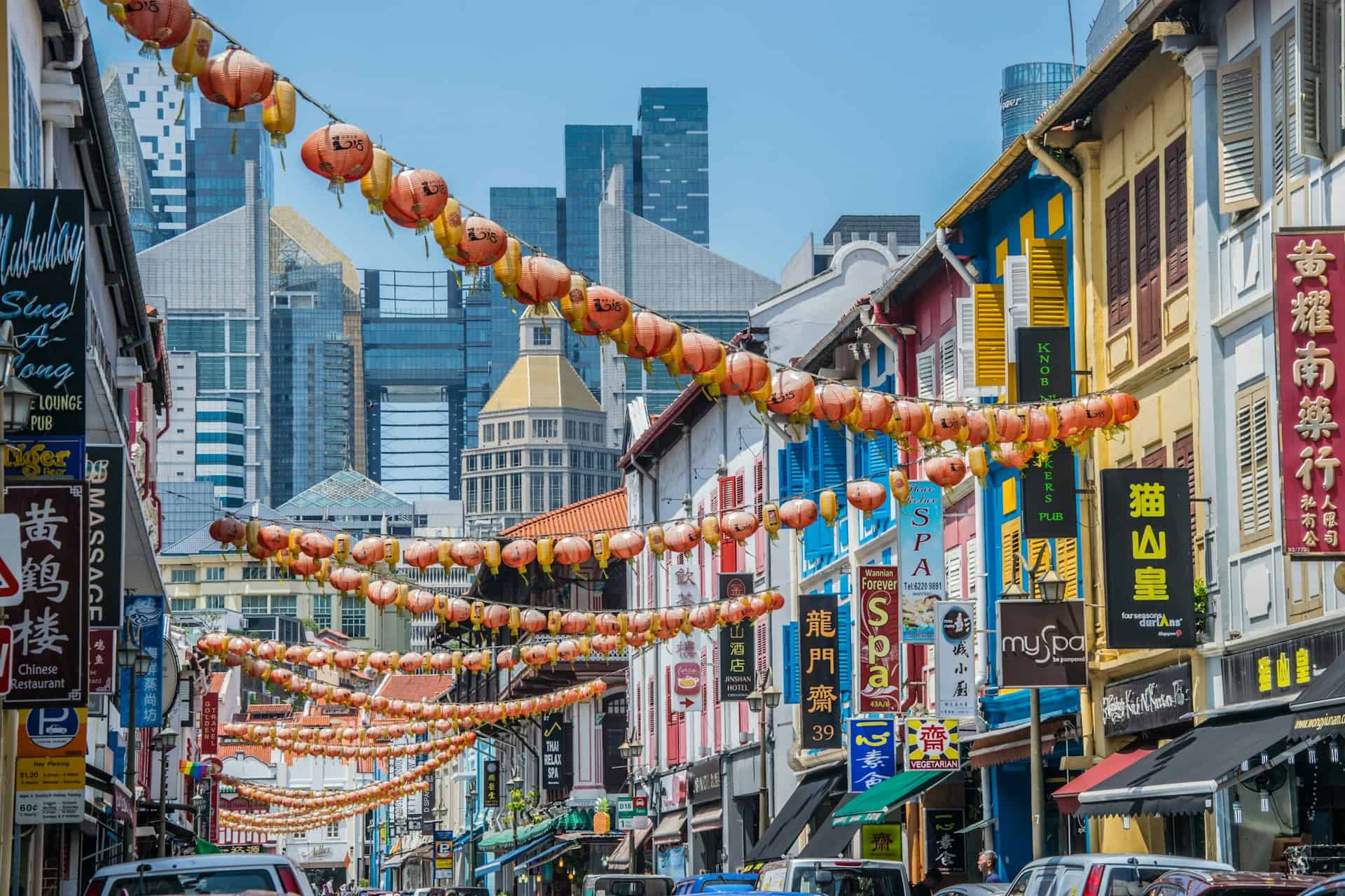 Colorful shophouses and hanging lanterns along a busy street in Chinatown, a popular place to visit in Singapore