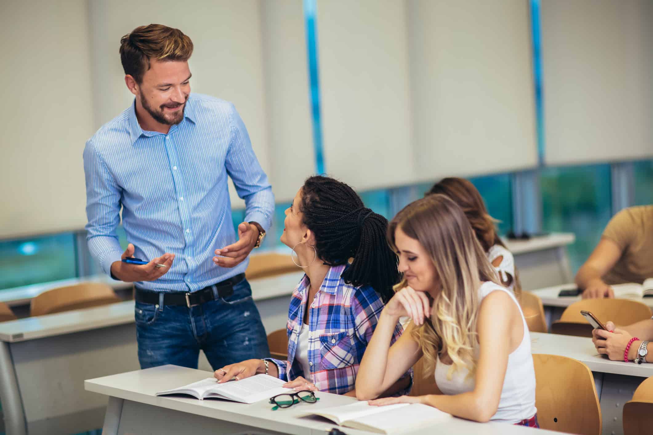 English teacher leading a classroom of adult students at a language school in Europe.
