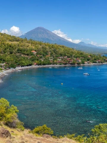 Aerial view of Amed's coastline with Mount Agung in the background, Bali, Indonesia.