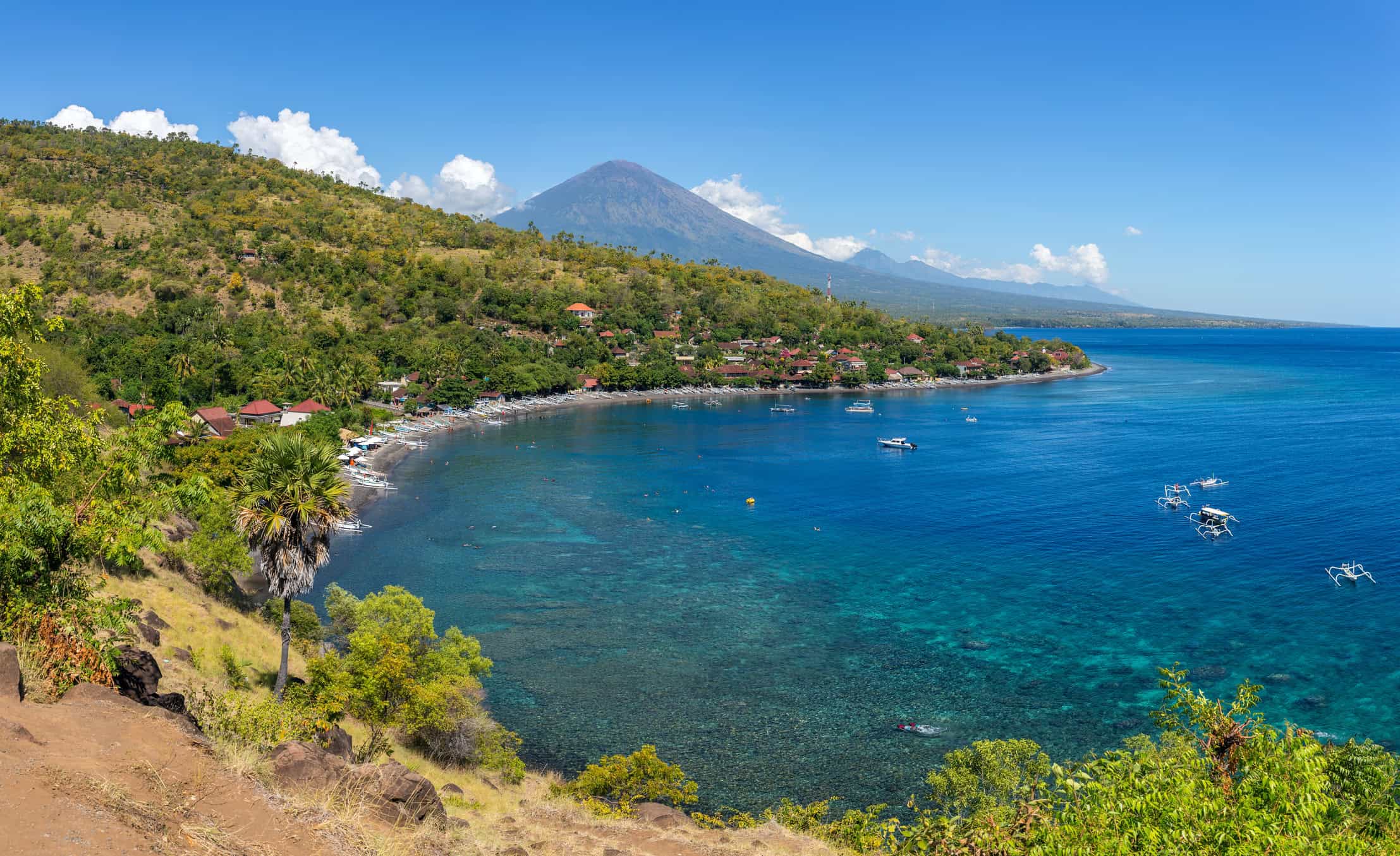 Aerial view of Amed's coastline with Mount Agung in the background, Bali, Indonesia.