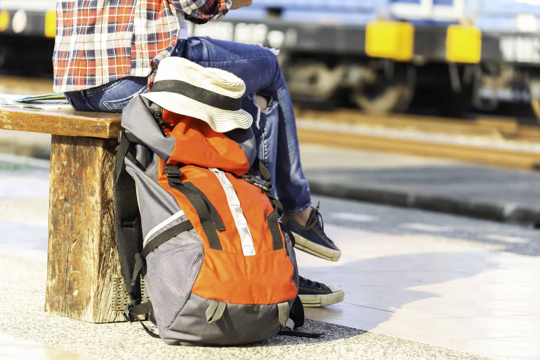 Backpack resting beside a traveler waiting for a train during an international backpacking trip.