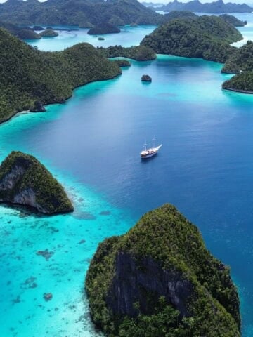 A liveaboard sailing through the limestone islands of Raja Ampat, Indonesia.