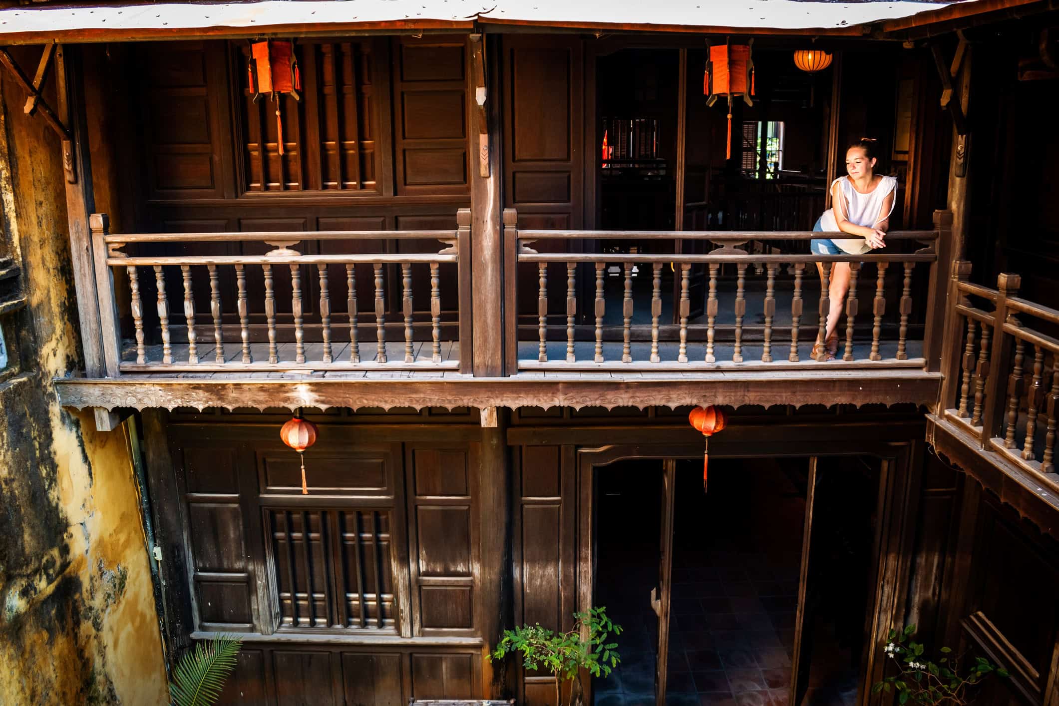 Traveler relaxing on the balcony of a traditional guesthouse in Hoi An, Vietnam.