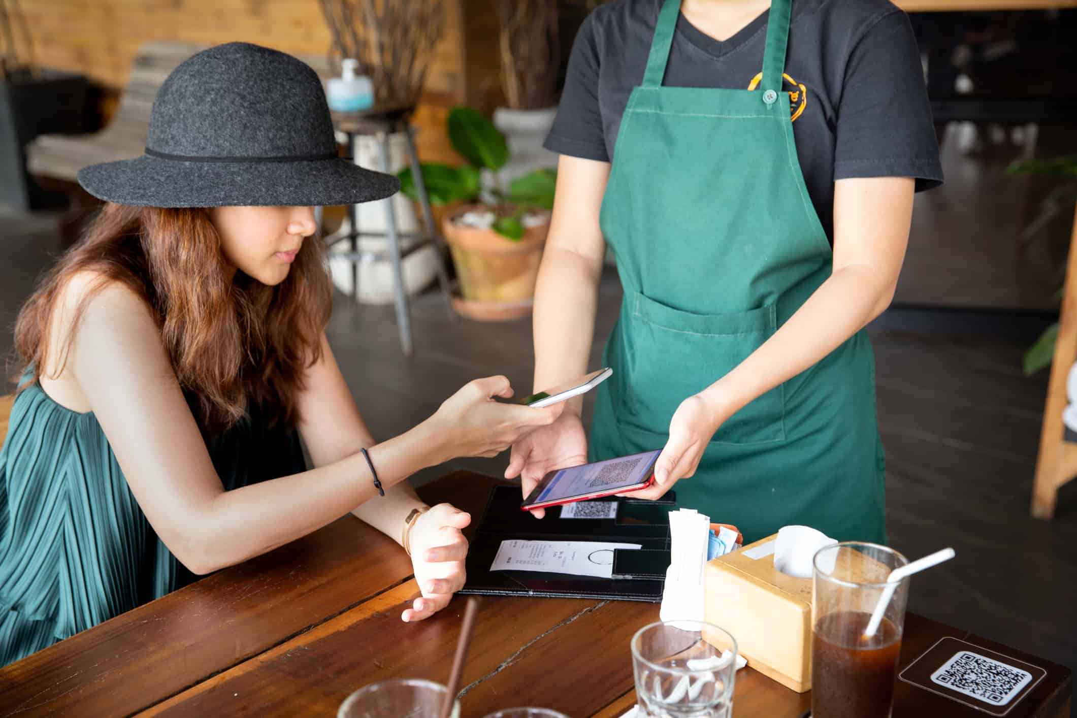 Traveler using a smartphone to pay at a restaurant in Thailand.
