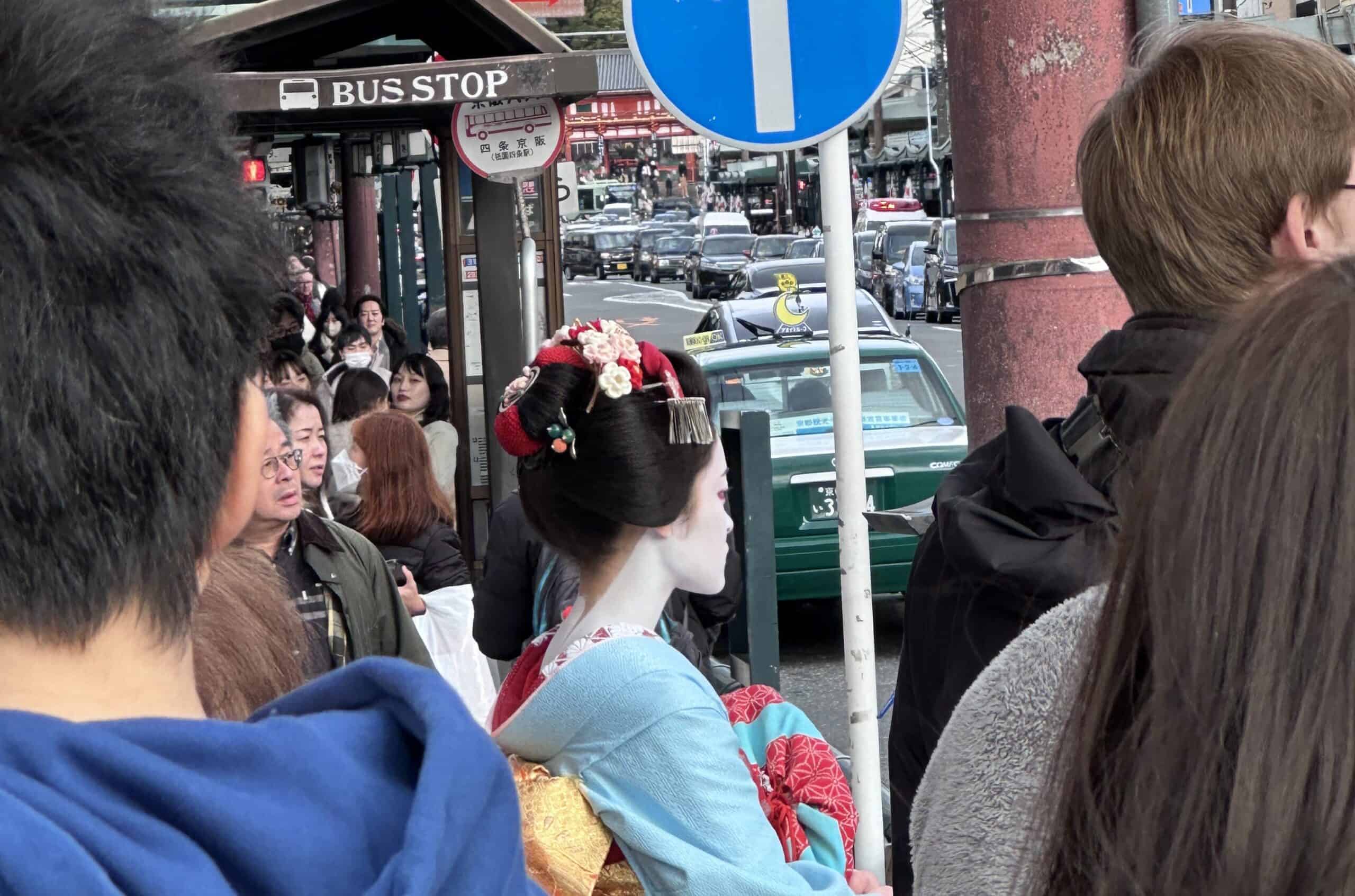 A maiko surrounded by crowds in Kyoto's Gion district