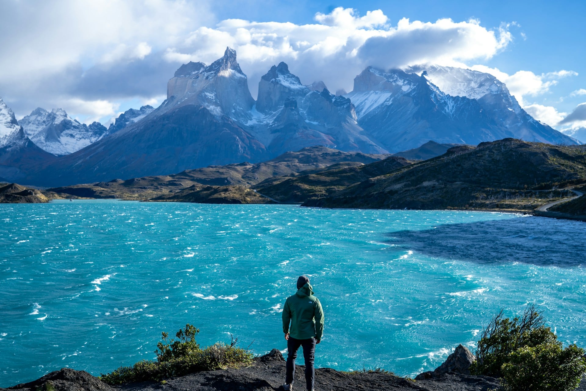 Hiker overlooking a mountain lake in Torres del Paine, Chile